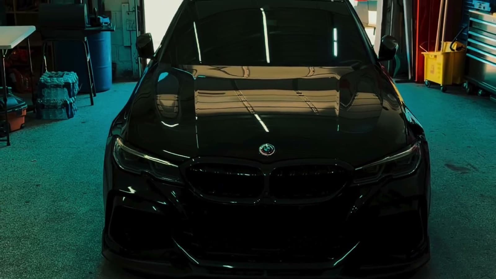 A black BMW M340i parked in a dark garage after a windshield replacement