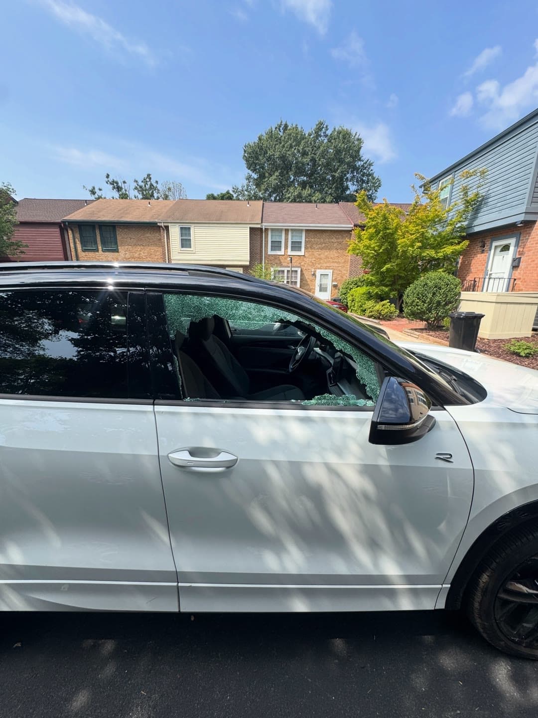 Shattered passenger door glass on a white Volkswagen, cleared and replaced in a Northern Virginia driveway