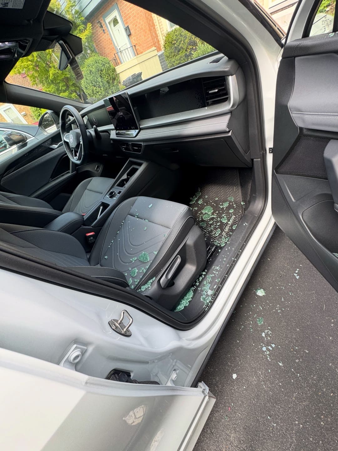 Shattered passenger door glass on a white Volkswagen, cleared and replaced in a Northern Virginia driveway