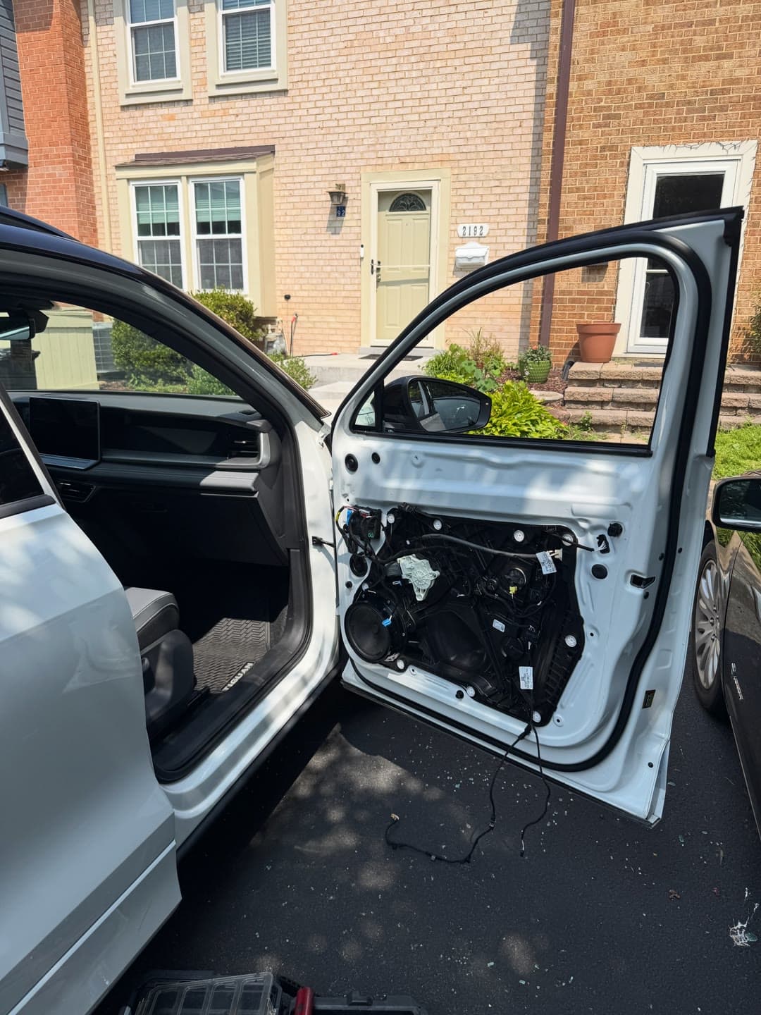 Shattered passenger door glass on a white Volkswagen, cleared and replaced in a Northern Virginia driveway