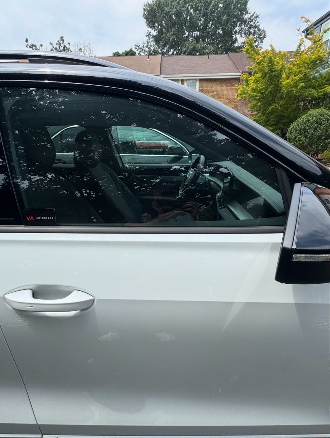 Shattered passenger door glass on a white Volkswagen, cleared and replaced in a Northern Virginia driveway
