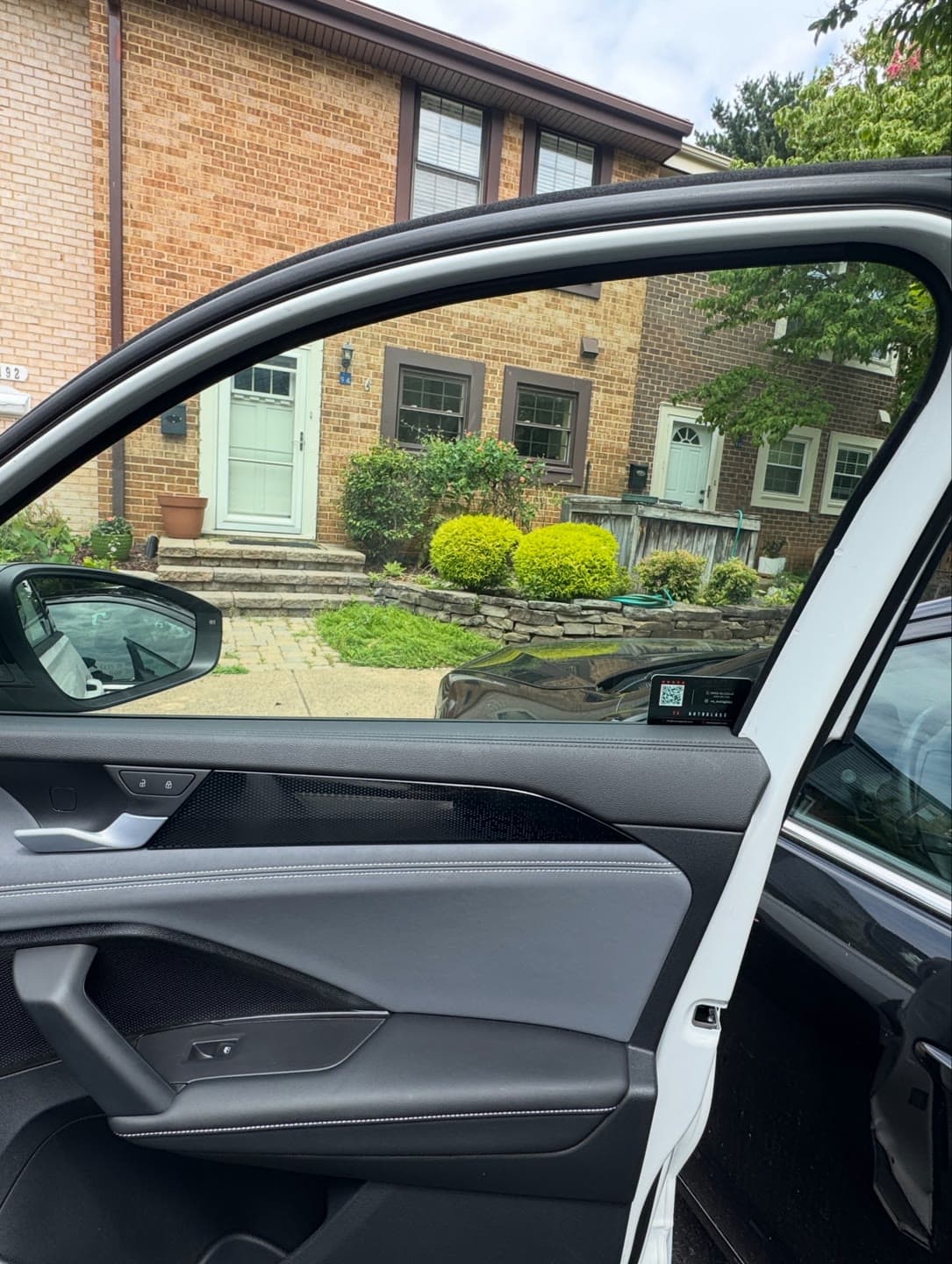 Shattered passenger door glass on a white Volkswagen, cleared and replaced in a Northern Virginia driveway