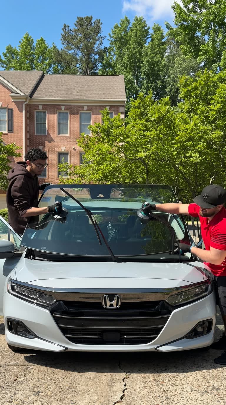 VA Auto Glass technicians setting a new windshield into a car in Northern Virginia
